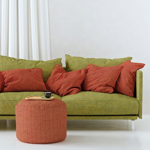 3D product render of a green fabric sofa with terracotta pillows and a chevron pouf — an example of a core CGI silo image for ecommerce