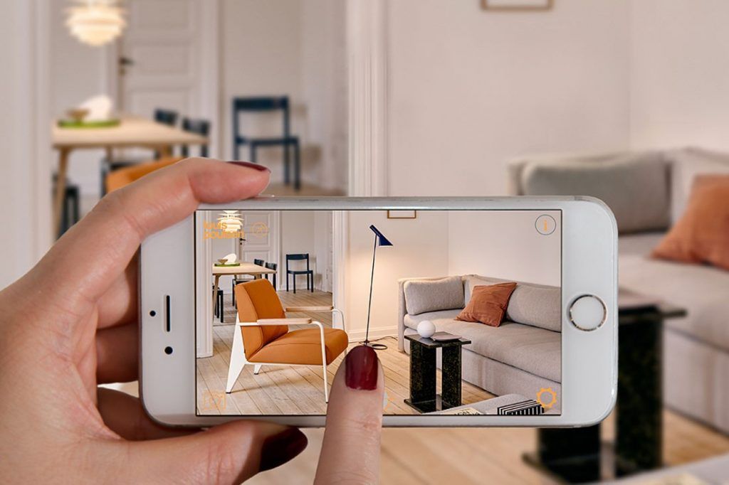 Furniture AR shopping experience on a smartphone — armchair, lamp, and side table placed in a real living room